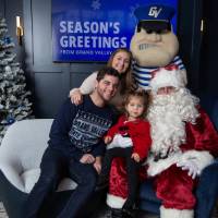 Parents with daughter on Santa's lap smile with Louie